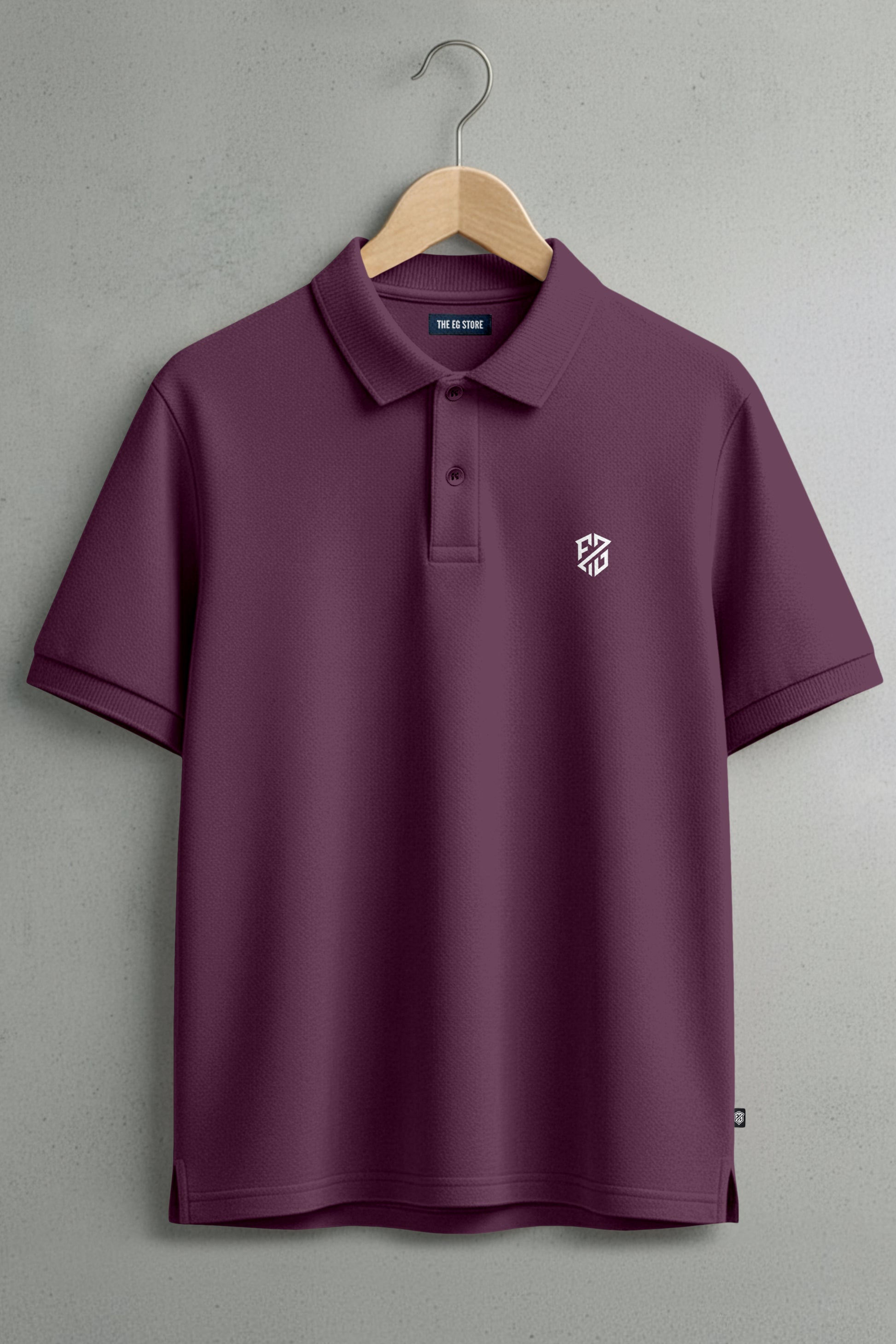 Maroon short sleeve polo shirt with collar, button placket, and white chest logo on hanger