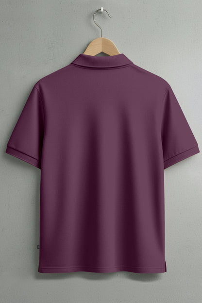 Back view of short-sleeve maroon polo shirt on hanger against gray wall