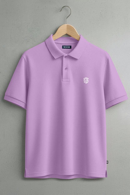 Lilac short-sleeve polo shirt with white logo, hanging on wooden hanger against gray wall