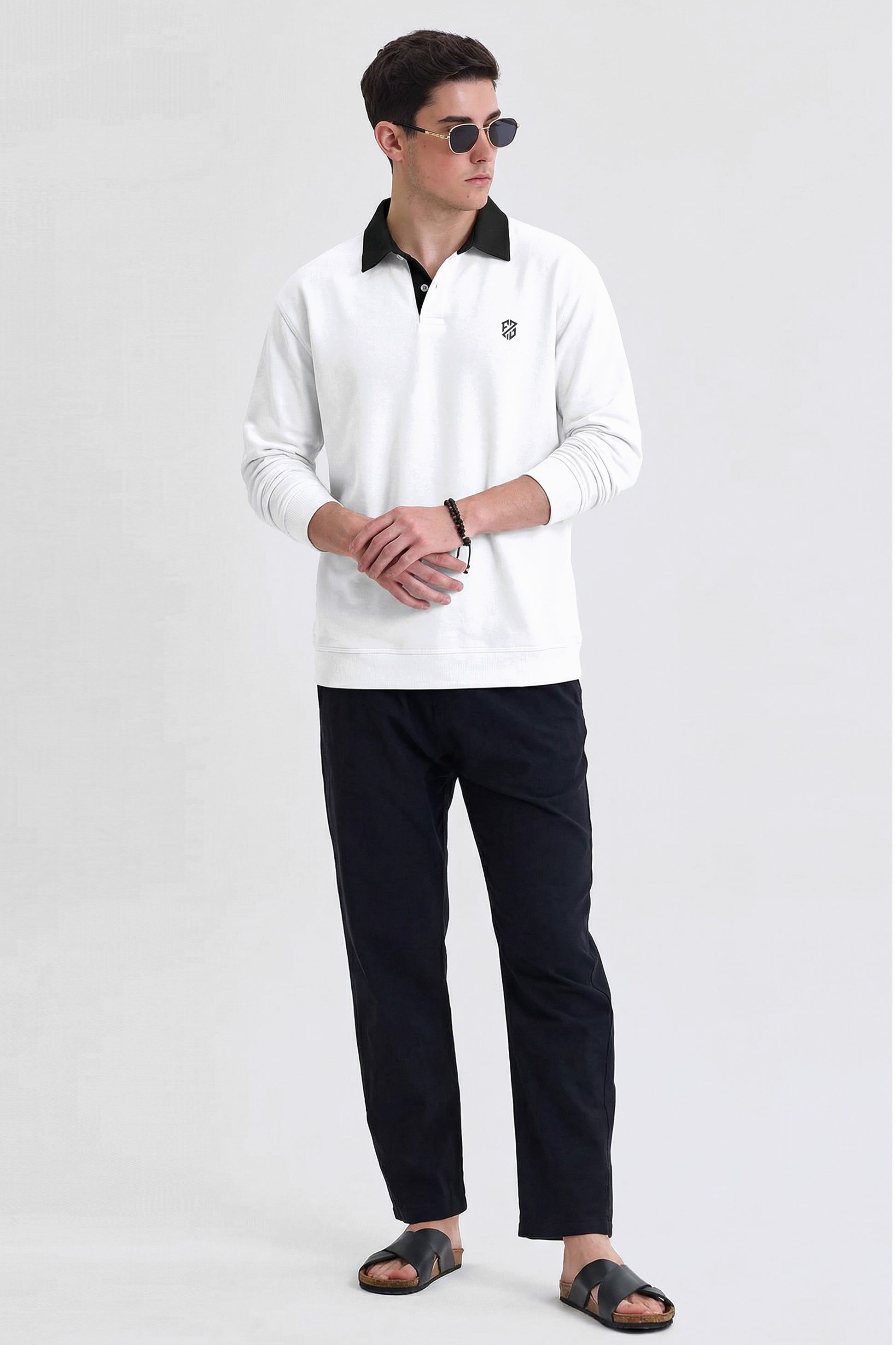 Man wearing white long-sleeve polo shirt, black pants, sandals, and sunglasses on plain background