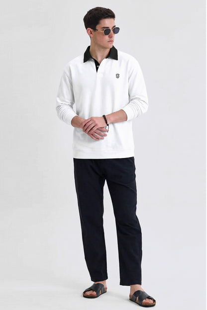 Man wearing white long-sleeve polo shirt, black pants, sandals, and sunglasses on plain background
