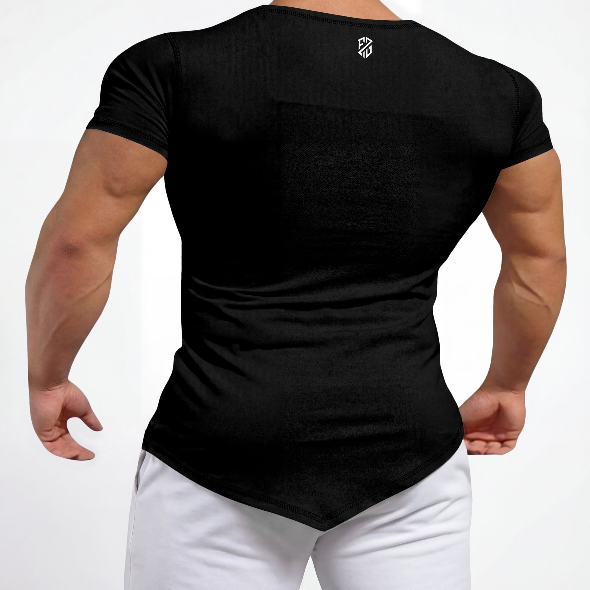 Back view of man wearing fitted black athletic t-shirt and white pants