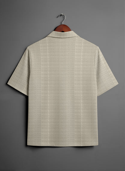 Beige textured short sleeve shirt on hanger against gray background, back view