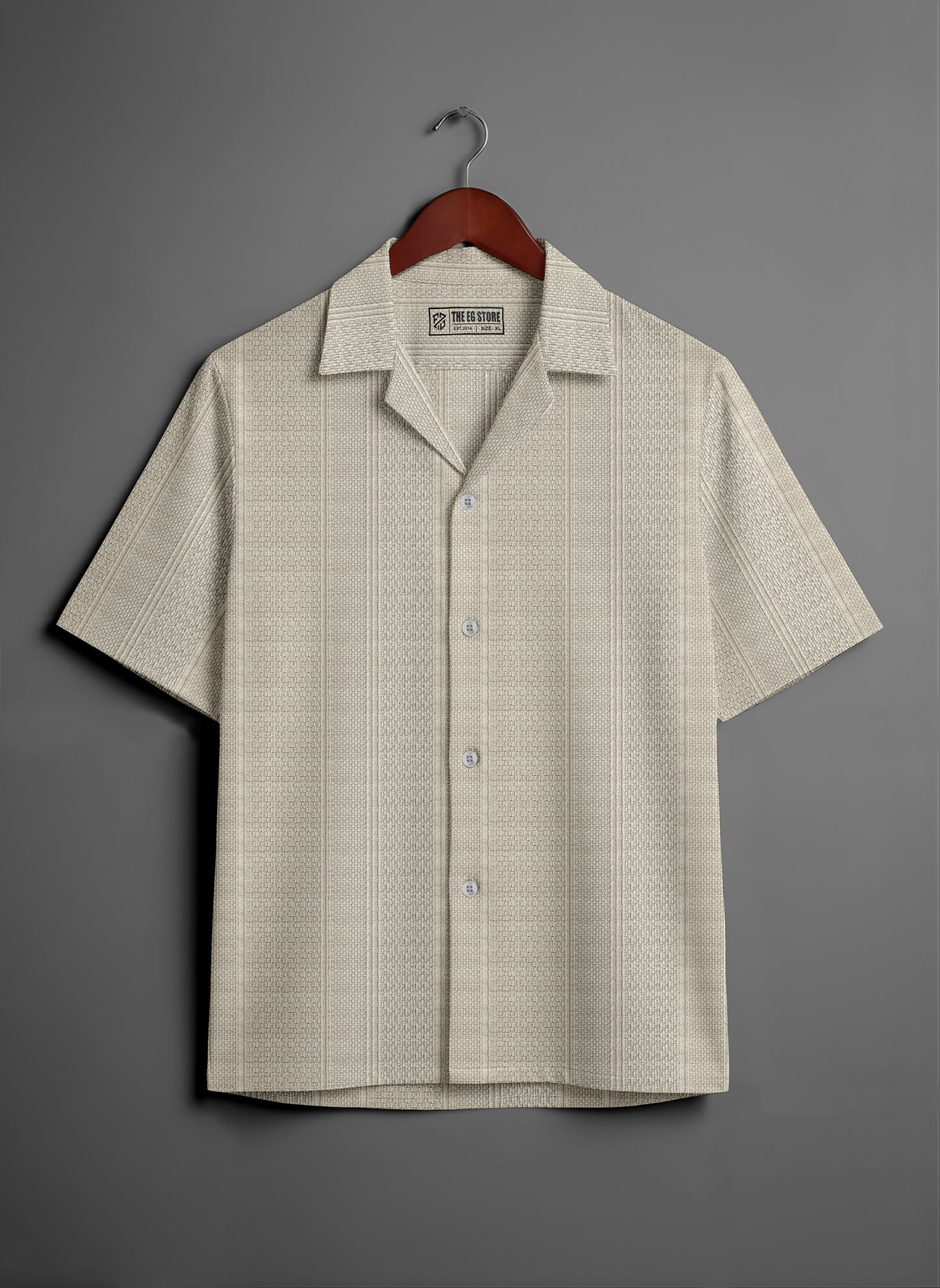 Beige short sleeve button-up shirt with subtle textured pattern on hanger, grey background