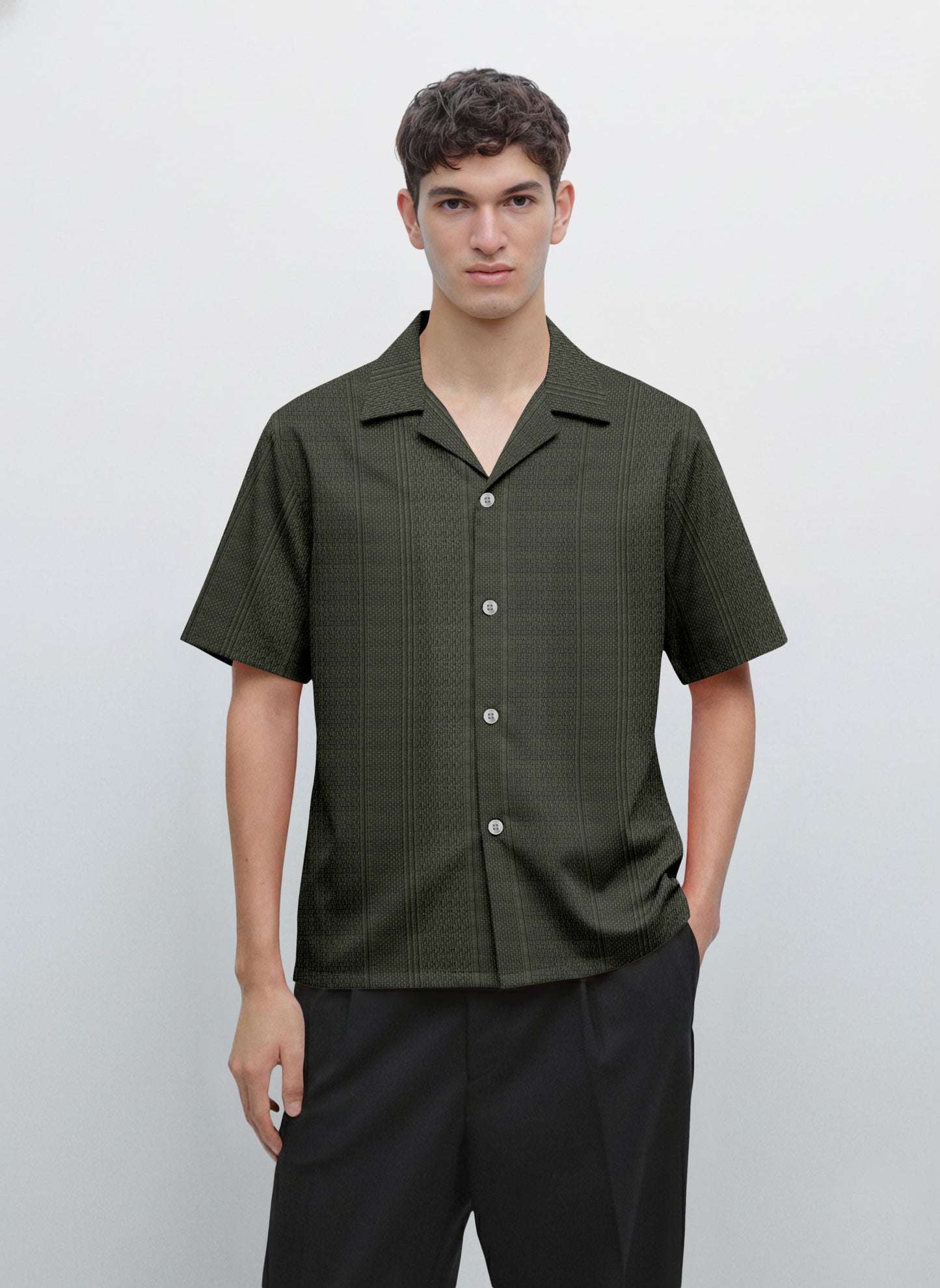 Man wearing a short sleeve dark green button-up shirt with subtle pattern