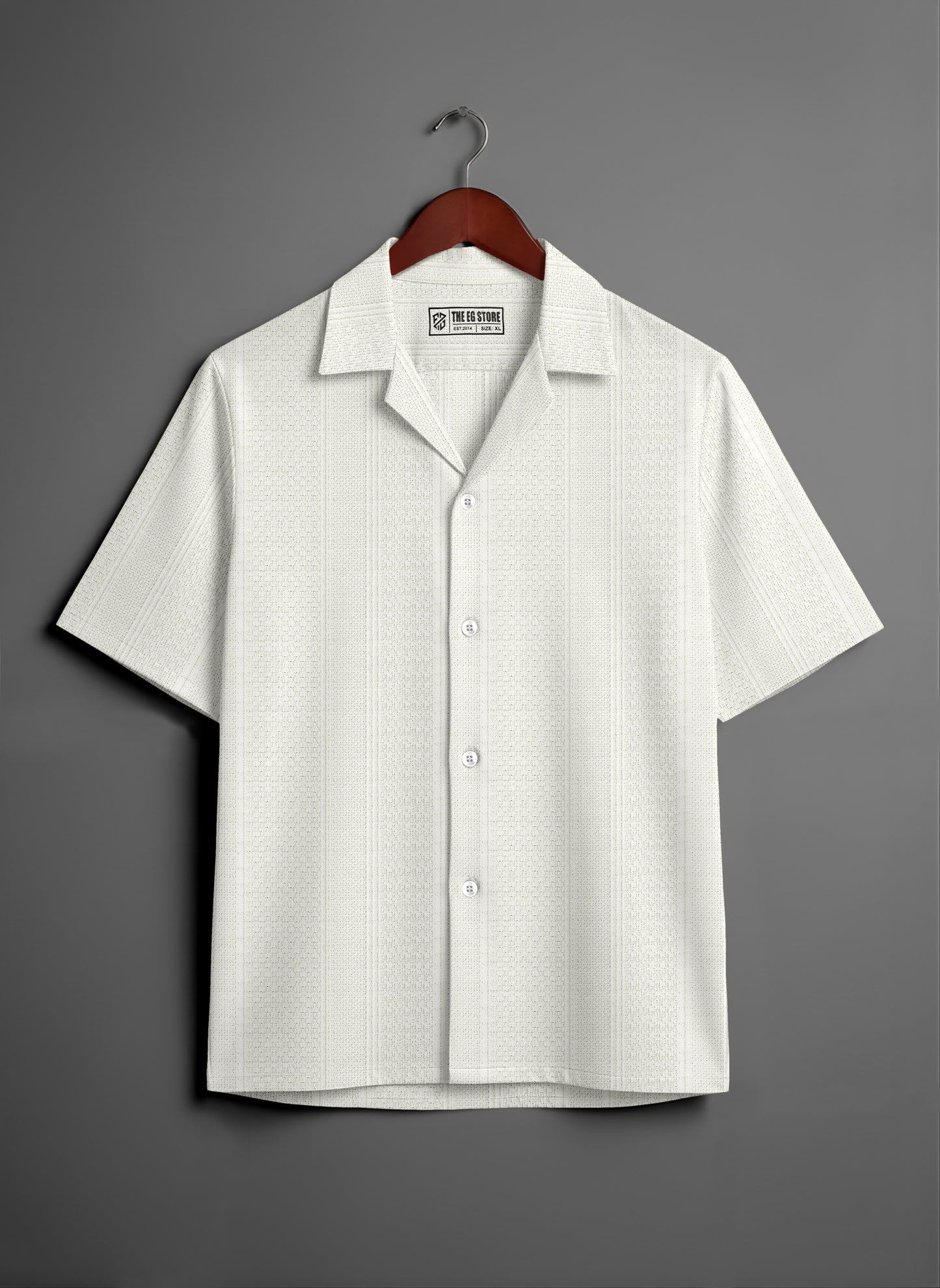 White short sleeve button-up shirt with subtle pattern on wooden hanger