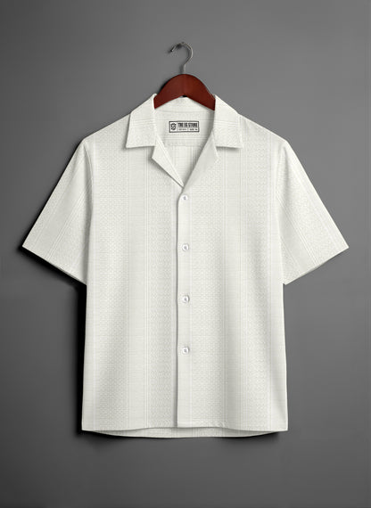 White short sleeve button-up shirt with subtle pattern on wooden hanger