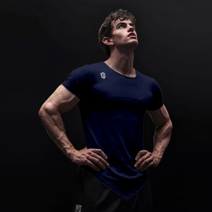 Athletic man in fitted navy blue gym t-shirt with logo, posing against dark background