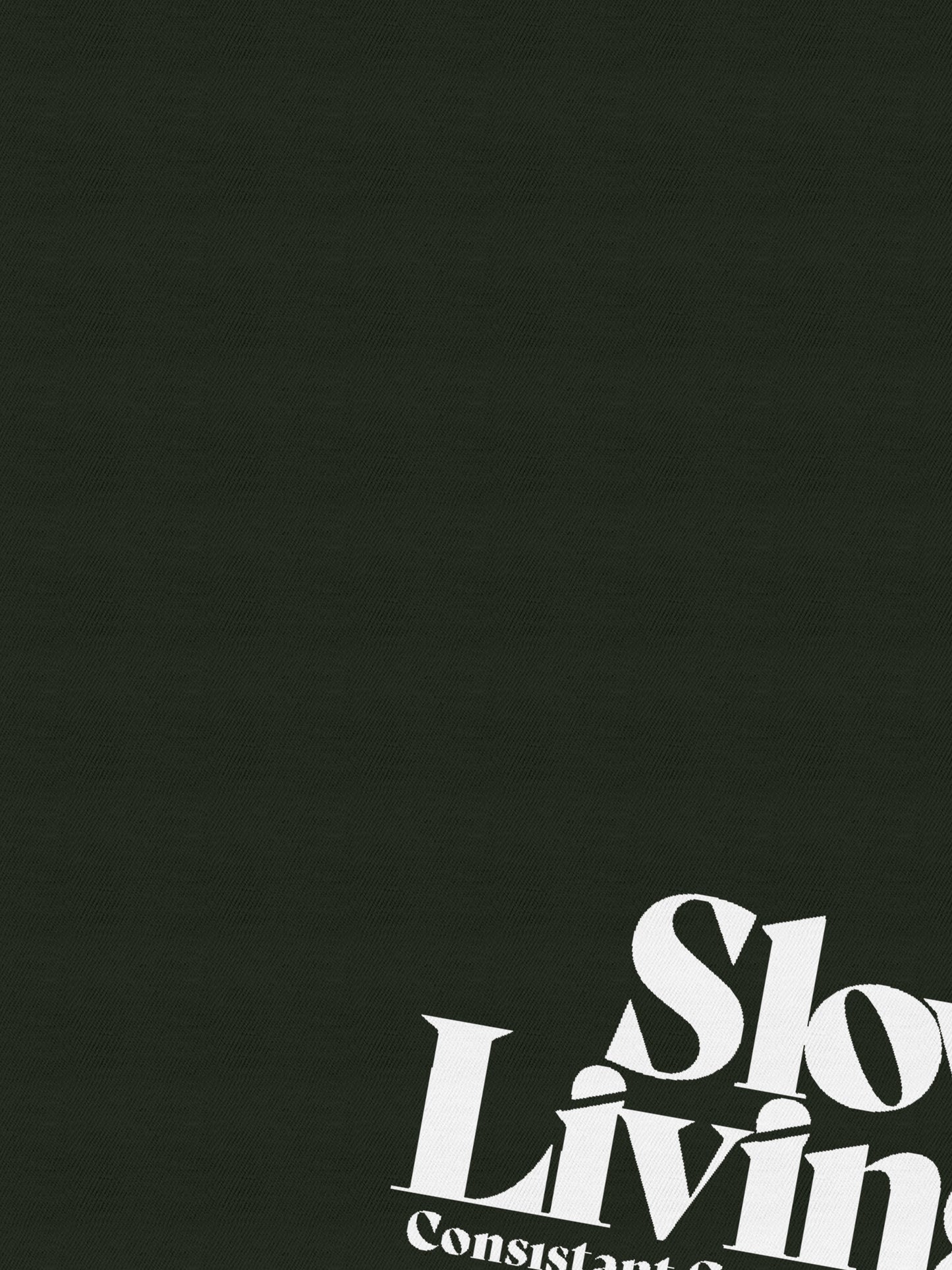 Dark green fabric with white text 'Slow Living' printed in bold, partial view angle